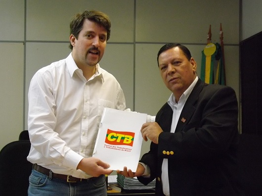Presidente do SEAACOM, José Providel, entrega documento ao Diretor-Presidente do Detran/RS, Leonardo Kauer.